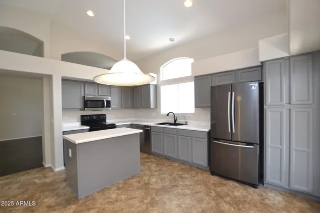 a kitchen with stainless steel appliances granite countertop a refrigerator a sink dishwasher a stove and a refrigerator