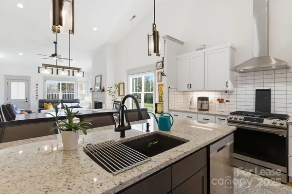 a kitchen with stainless steel appliances granite countertop a sink stove and refrigerator