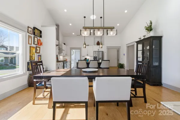 a dining room with furniture a chandelier and wooden floor
