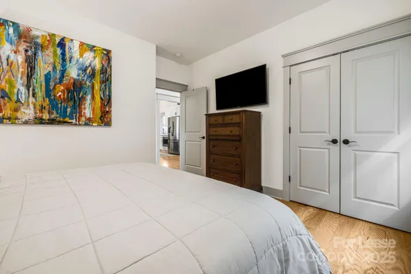a bedroom with a bed and painting on the wall