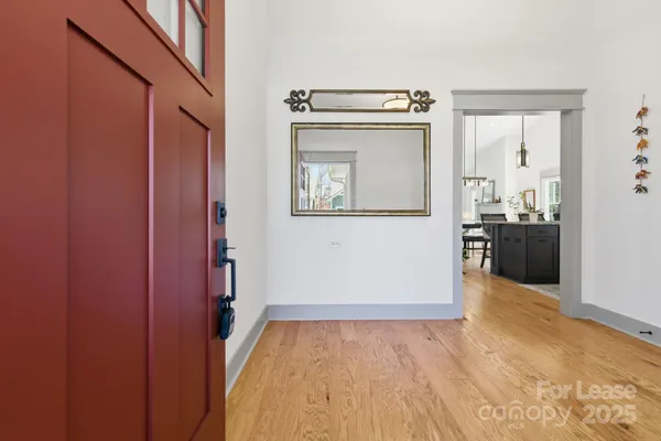 a view of a hallway with wooden floor and staircase