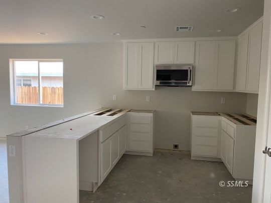1213 Mayo Street Ridgecrest, CA 93555 - Photo 2 of 30 a kitchen with white cabinets and white appliances