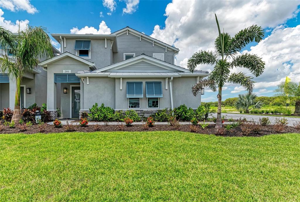 a front view of a house with a yard and potted plants