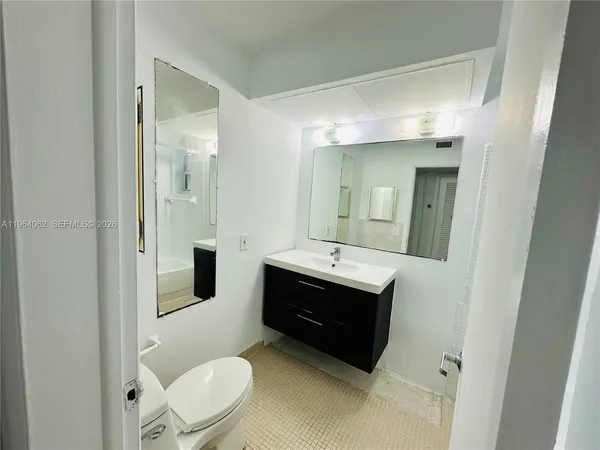 a spacious bathroom with a toilet a sink and mirror