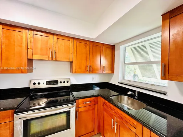 a kitchen with a sink a stove and cabinets