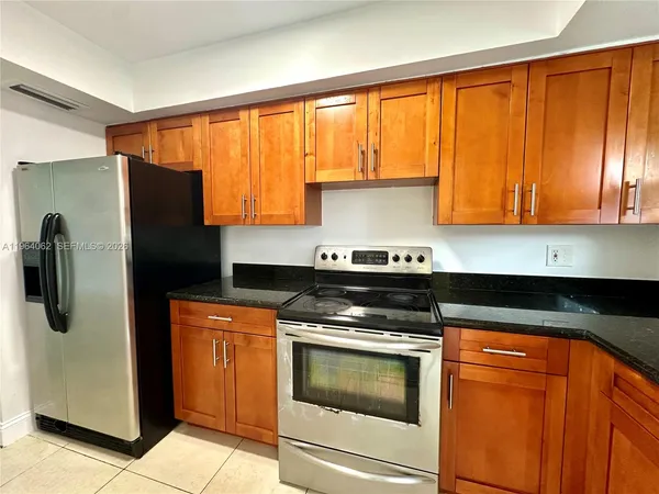 a kitchen with stainless steel appliances granite countertop cabinets and a refrigerator