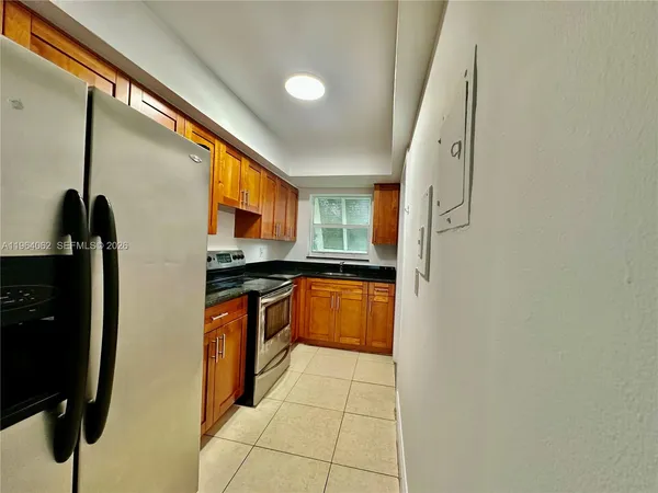 a kitchen with stainless steel appliances granite countertop a refrigerator and a stove top oven