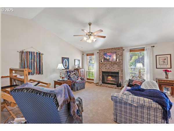 261 Southwest Nancy Circle Gresham, OR 97030 - Photo 3 of 25 a living room with furniture a fireplace and a flat screen tv