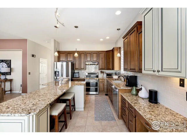 a kitchen with stainless steel appliances granite countertop sink refrigerator and microwave