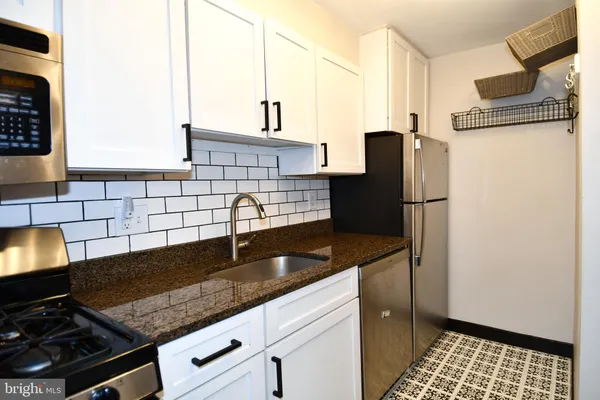 a kitchen with a sink a stove and cabinets