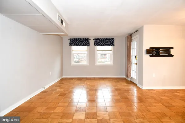 a view of a livingroom with an empty space wooden floor and a window
