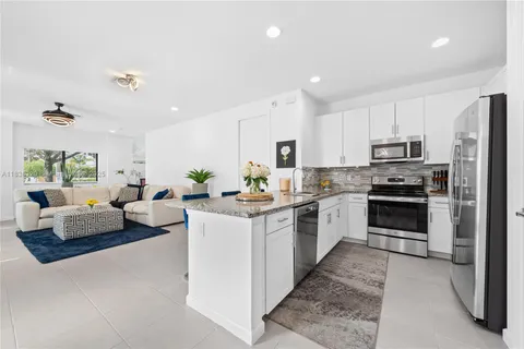 a large white kitchen with stainless steel appliances