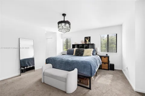 a spacious bedroom with a bed and a chandelier