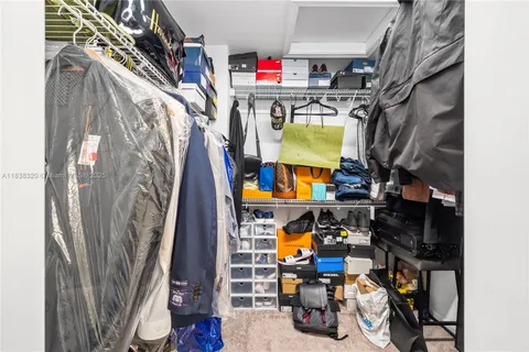 a view of walk in closet with clothes and shoes