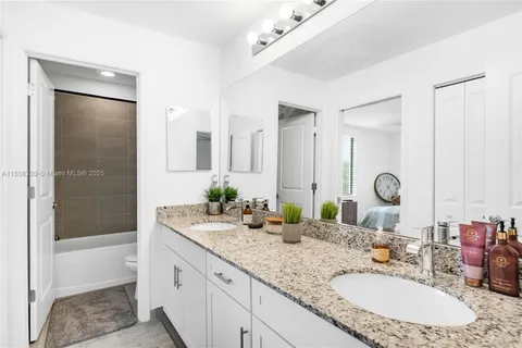 a bathroom with a granite countertop sink mirror and a bathtub