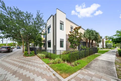 a front view of a house with a yard and trees
