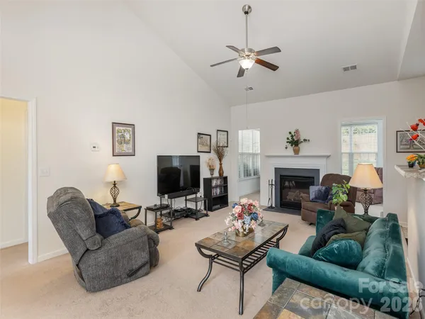 a living room with furniture a fireplace and a flat screen tv