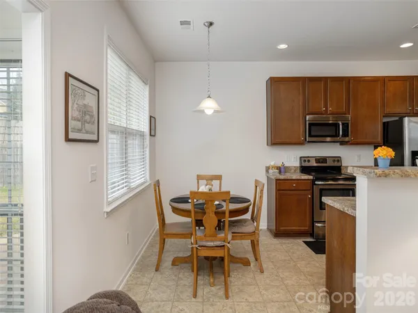 a kitchen with a dining table chairs and a refrigerator