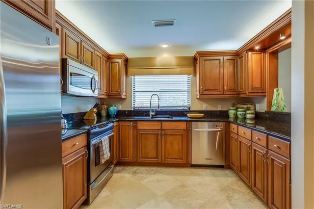 a kitchen with stainless steel appliances granite countertop a stove a sink and a refrigerator