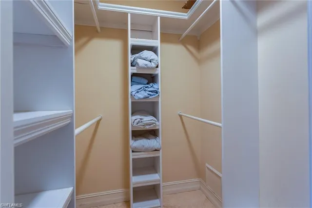 a view of walk in closet with clothes and shoes
