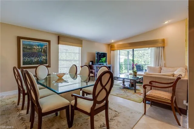 a dining room with furniture and a floor to ceiling window