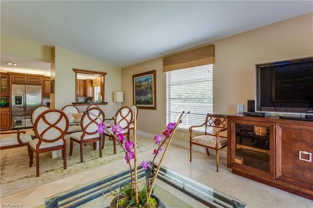 a living room with furniture a flat screen tv and a window