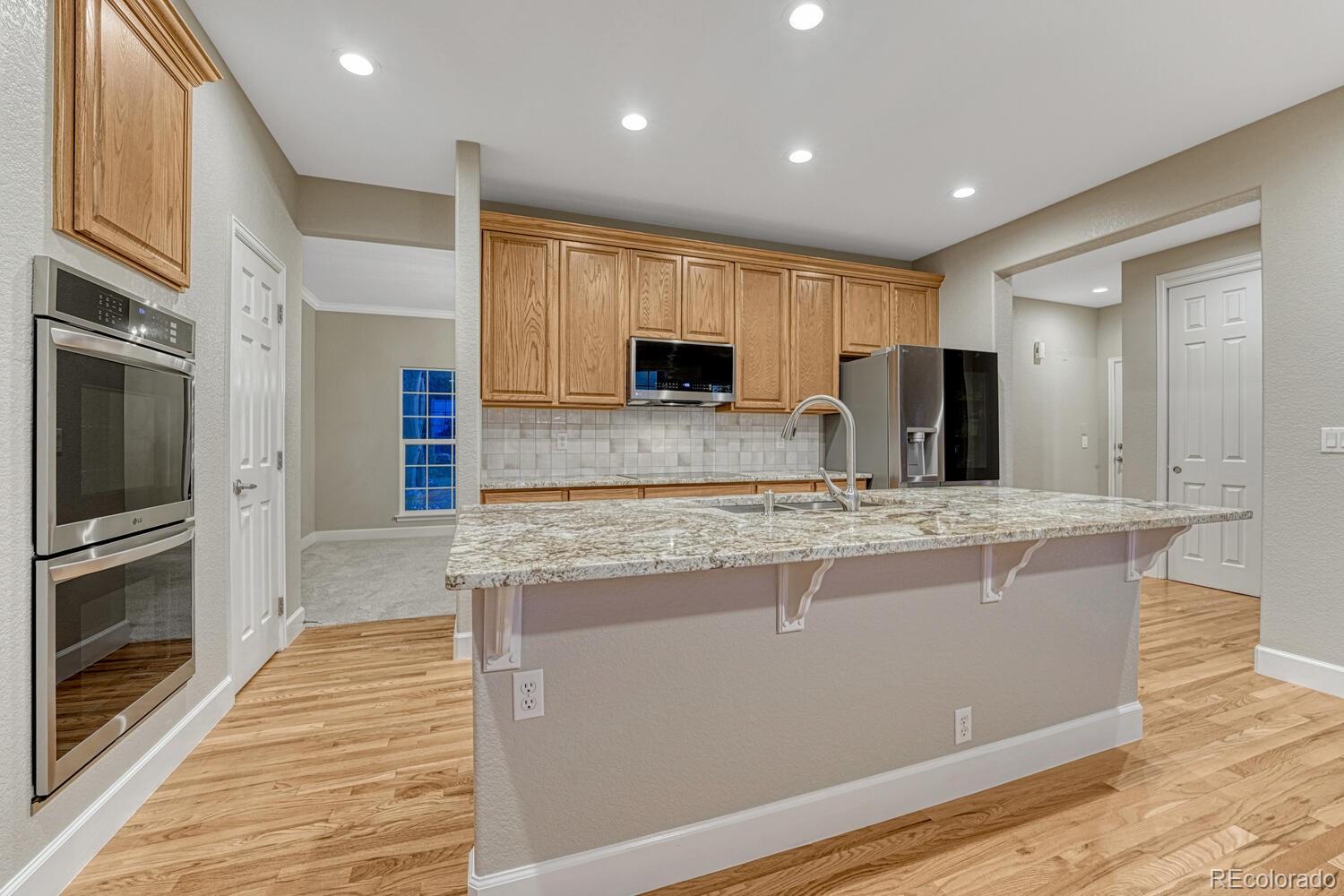 12350 Turquoise Terrace Street Castle Pines, CO 80108 - Photo 17 of 50 a large kitchen with stainless steel appliances granite countertop a stove a sink and a refrigerator