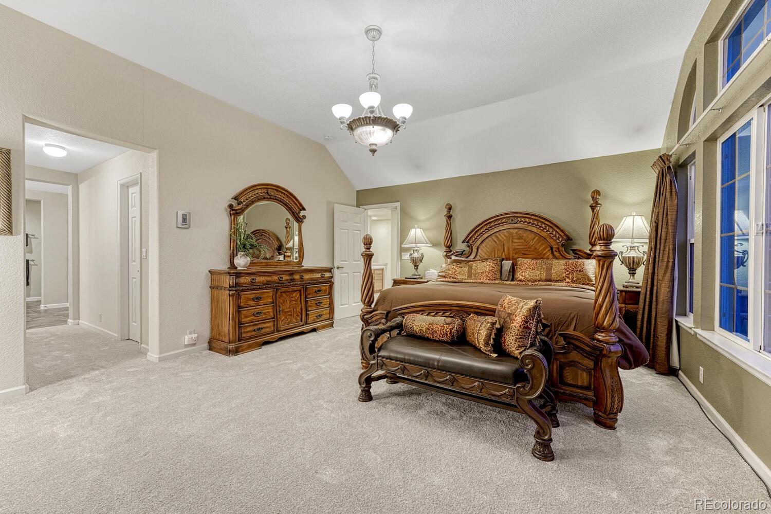 12350 Turquoise Terrace Street Castle Pines, CO 80108 - Photo 20 of 50 a bedroom with bed and a chandelier