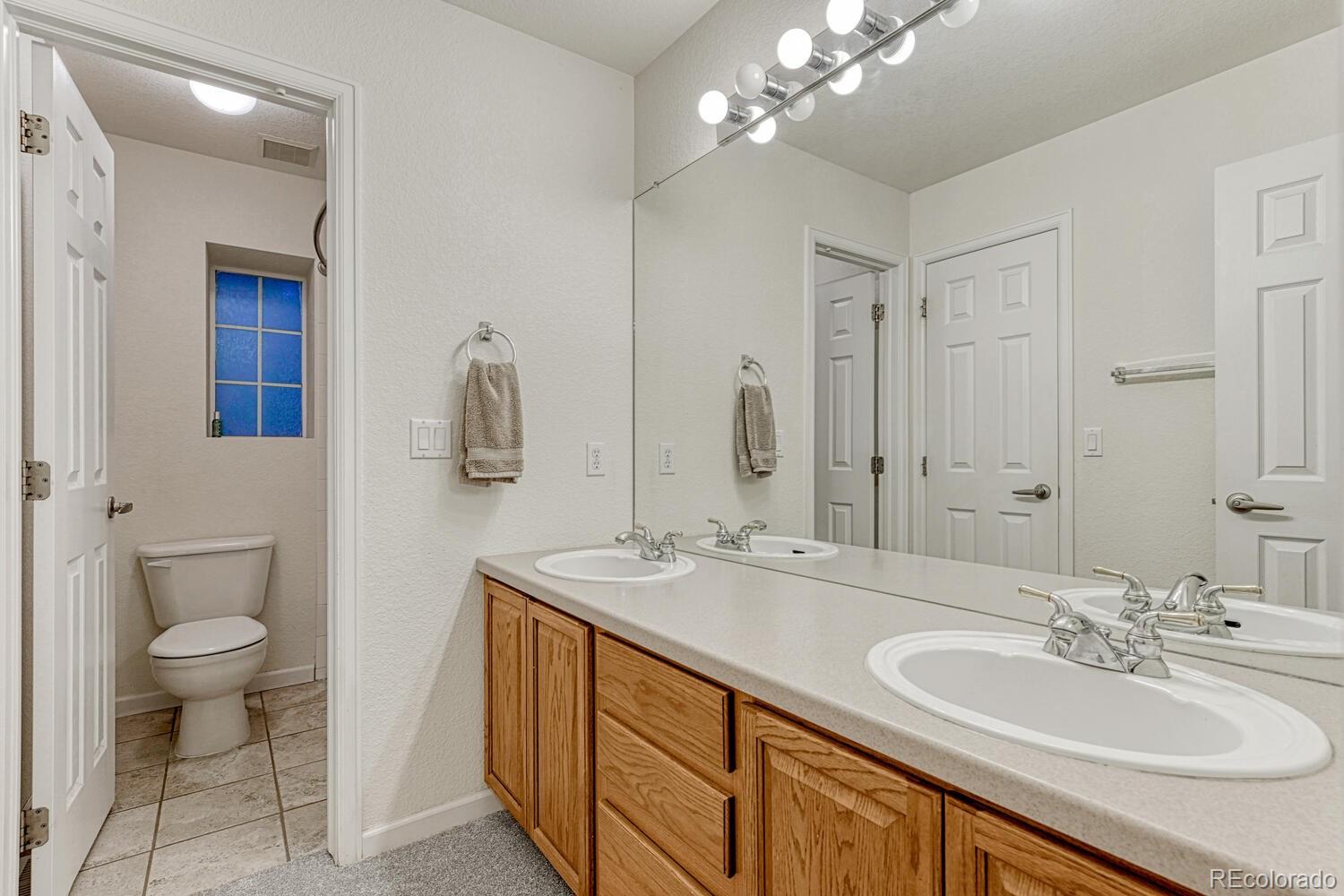 12350 Turquoise Terrace Street Castle Pines, CO 80108 - Photo 25 of 50 a bathroom with a sink double vanity and a toilet