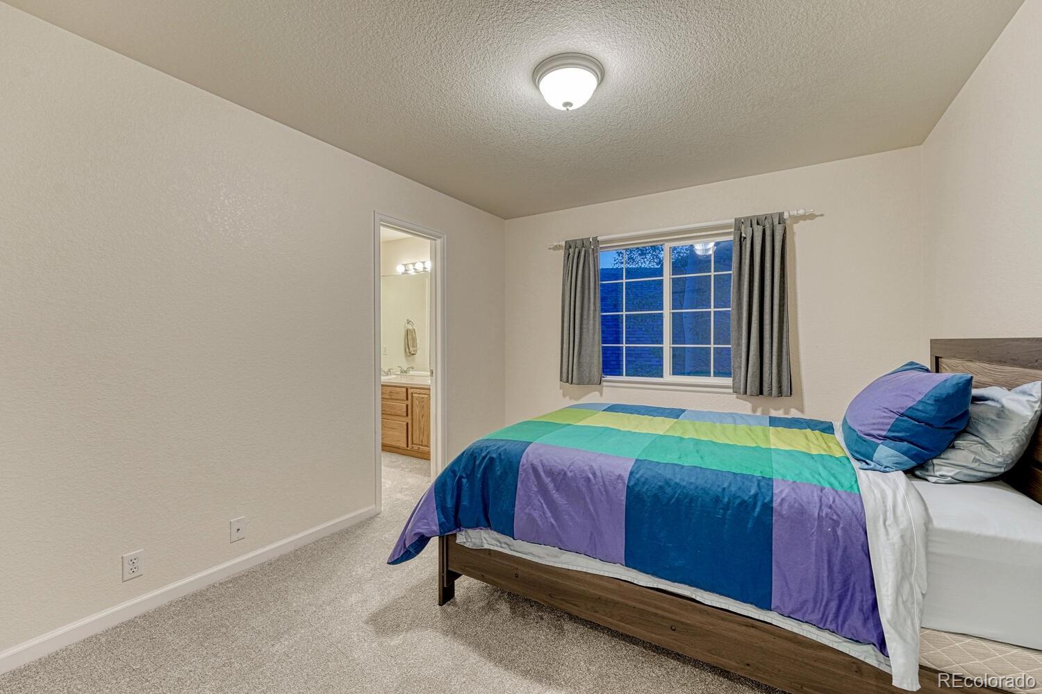 12350 Turquoise Terrace Street Castle Pines, CO 80108 - Photo 26 of 50 a bedroom with a bed and a window