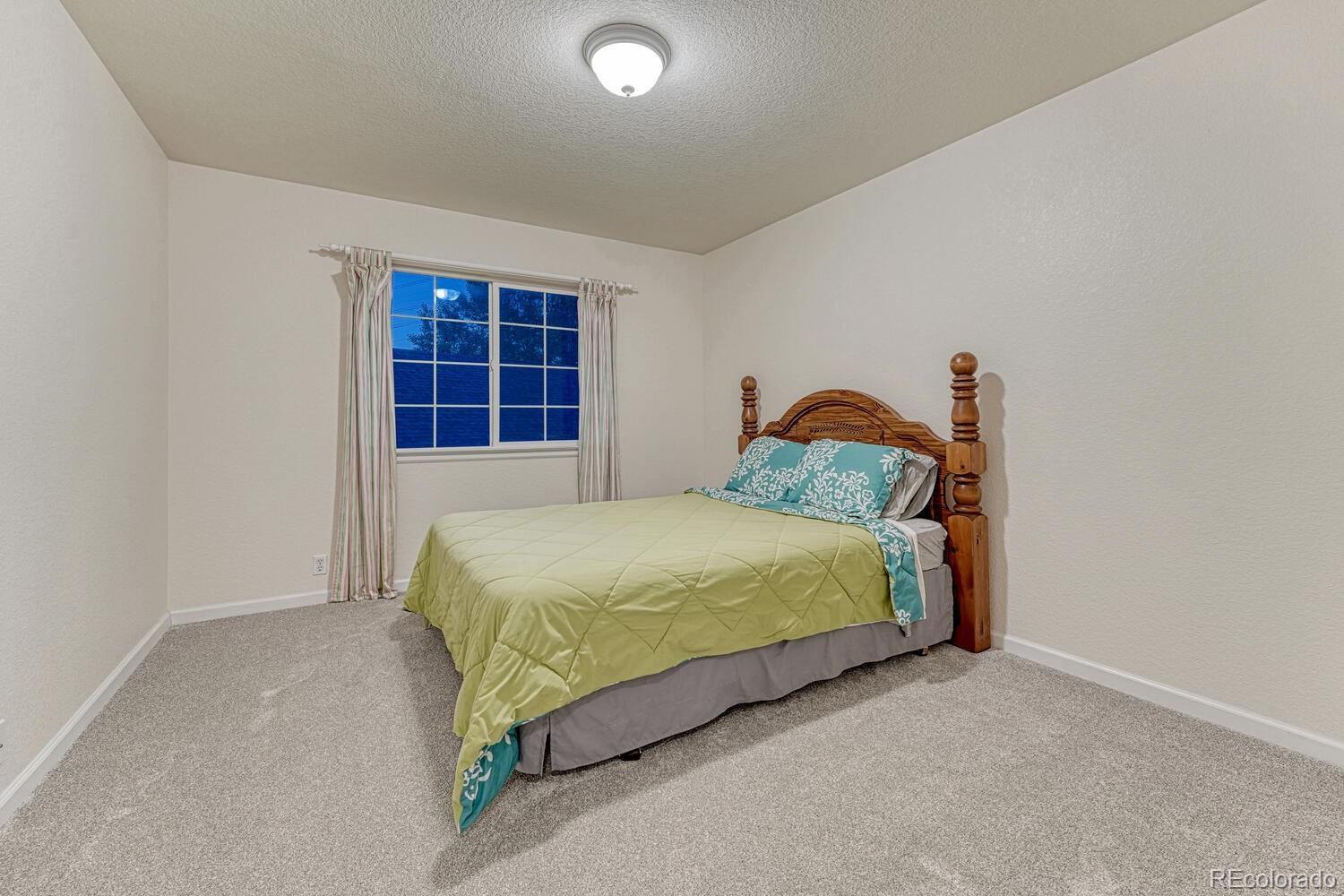 12350 Turquoise Terrace Street Castle Pines, CO 80108 - Photo 27 of 50 a bedroom with a bed and a window