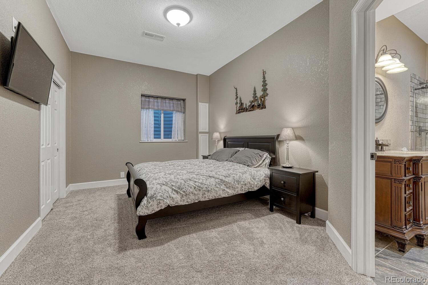 12350 Turquoise Terrace Street Castle Pines, CO 80108 - Photo 33 of 50 a bedroom with a bed a mirror and dresser