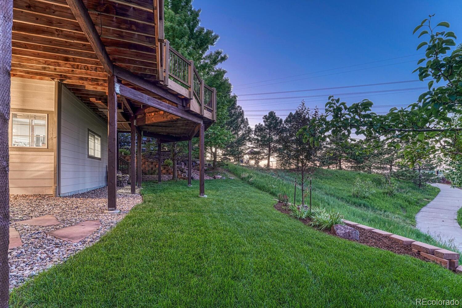 12350 Turquoise Terrace Street Castle Pines, CO 80108 - Photo 35 of 50 a view of a backyard with plants and a large tree