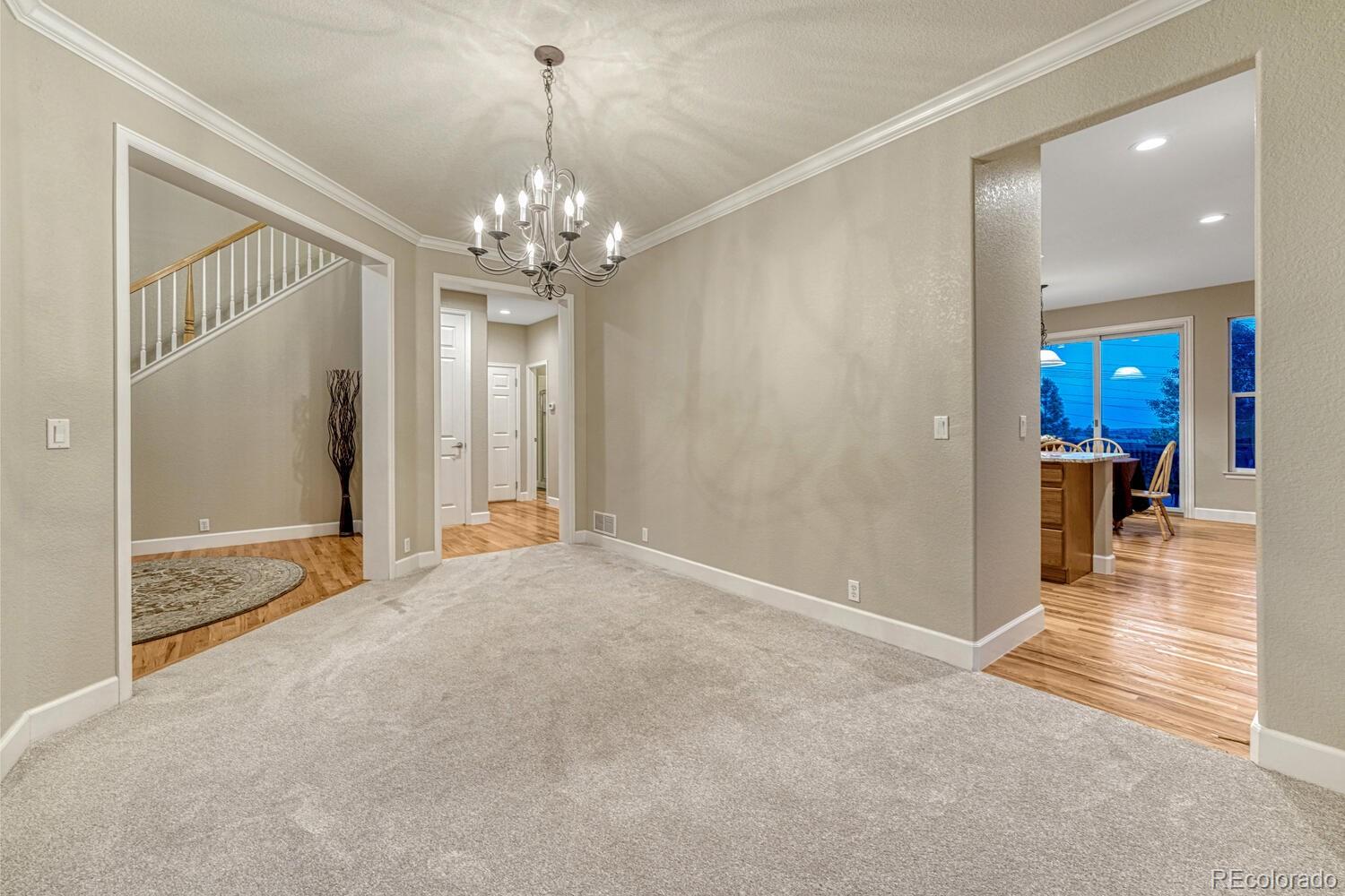 12350 Turquoise Terrace Street Castle Pines, CO 80108 - Photo 7 of 50 a view of a hallway with wooden floor and a chandelier