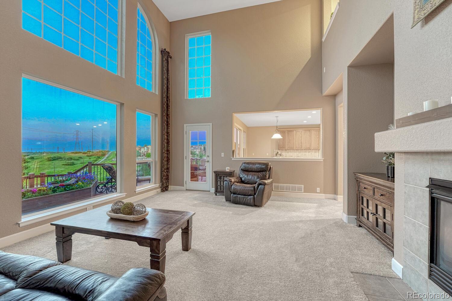 12350 Turquoise Terrace Street Castle Pines, CO 80108 - Photo 9 of 50 a living room with fireplace furniture and a large window