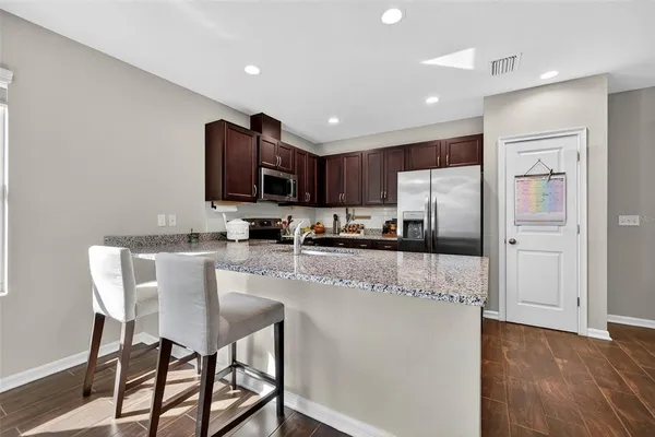 a kitchen with stainless steel appliances granite countertop a sink stove and microwave