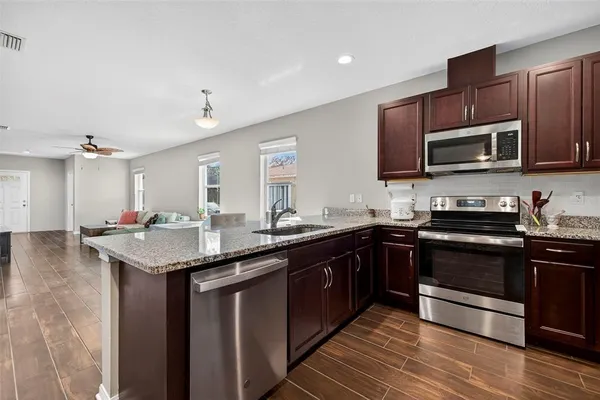 a kitchen with granite countertop wooden cabinets and stainless steel appliances