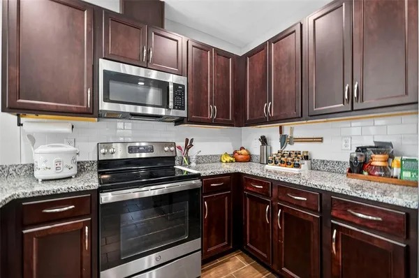 a kitchen with stainless steel appliances granite countertop a refrigerator sink and microwave