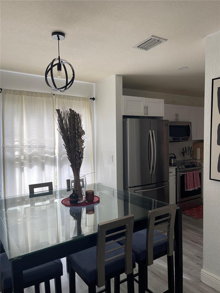 2432 Southwest 99th Way Miramar, FL 33025 - Photo 4 of 17 a view of a dining room with furniture wooden floor and kitchen