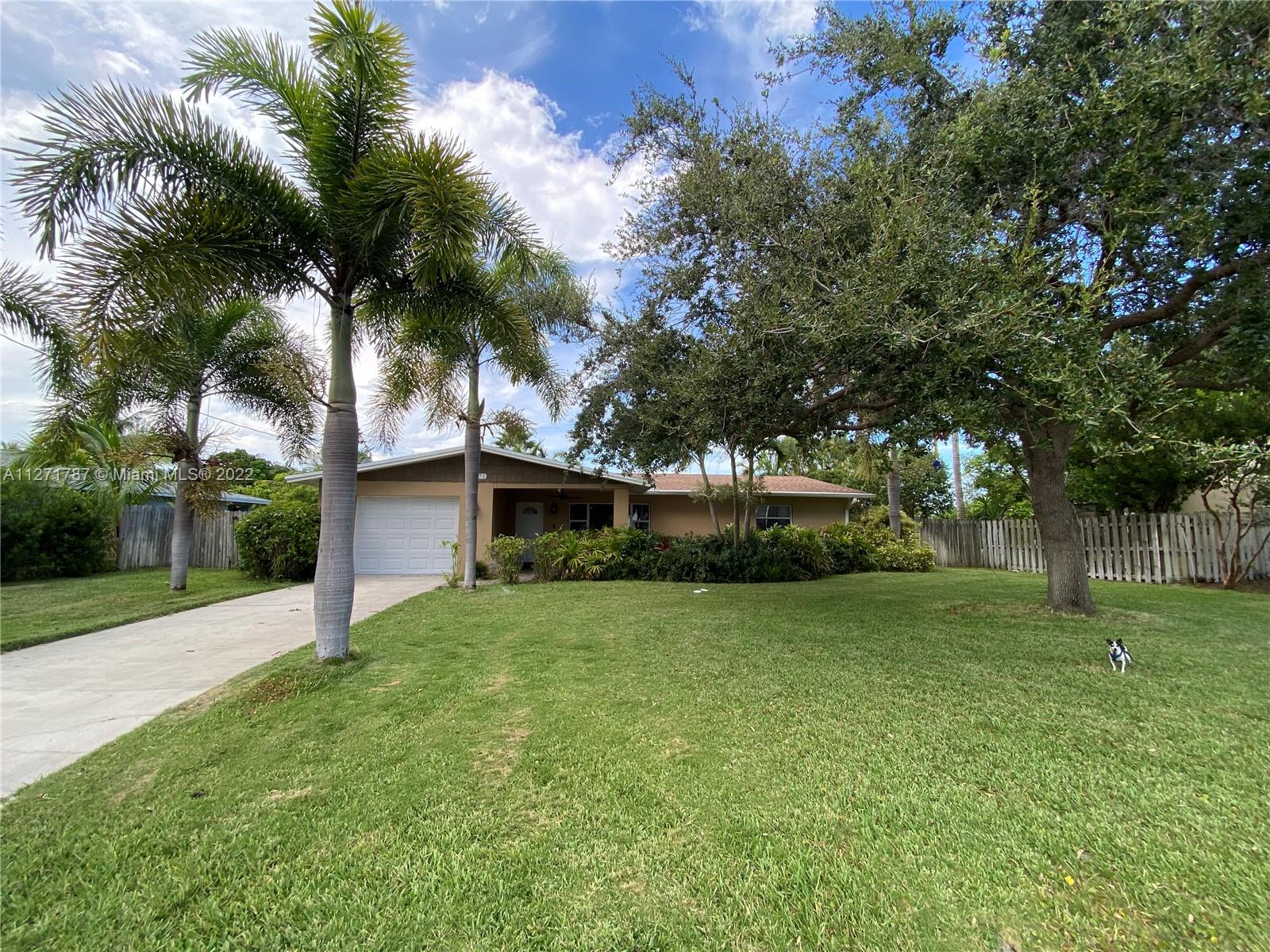 1672 Thumb Point Drive Fort Pierce, FL 34949 - Photo 2 of 29 a front view of a house with a yard and palm trees