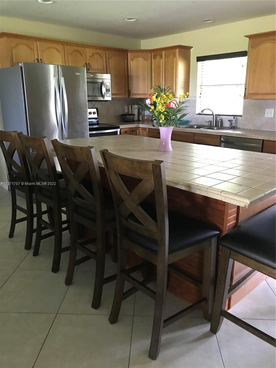 1672 Thumb Point Drive Fort Pierce, FL 34949 - Photo 10 of 29 a kitchen with stainless steel appliances granite countertop table chairs sink and window