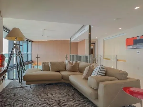 a living room with furniture and a floor to ceiling window