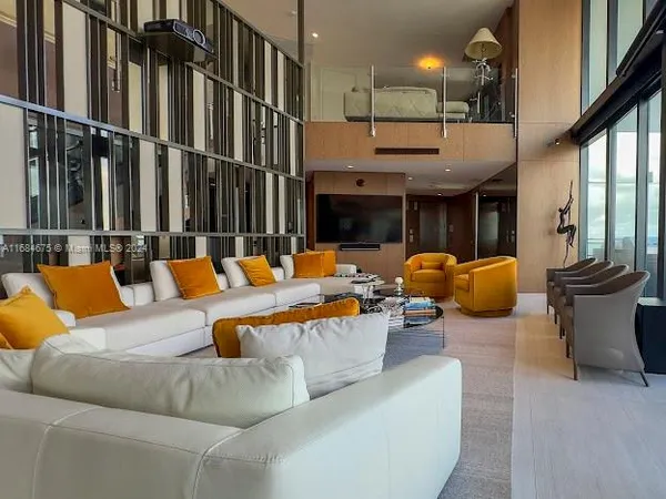 a bedroom with a large bed and a large window with balcony view