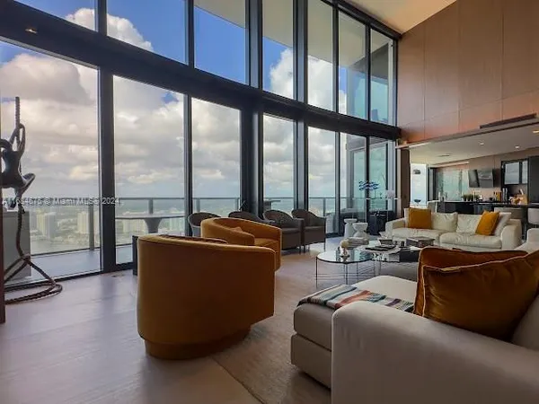 a living room with furniture a floor to ceiling window and a flat screen tv