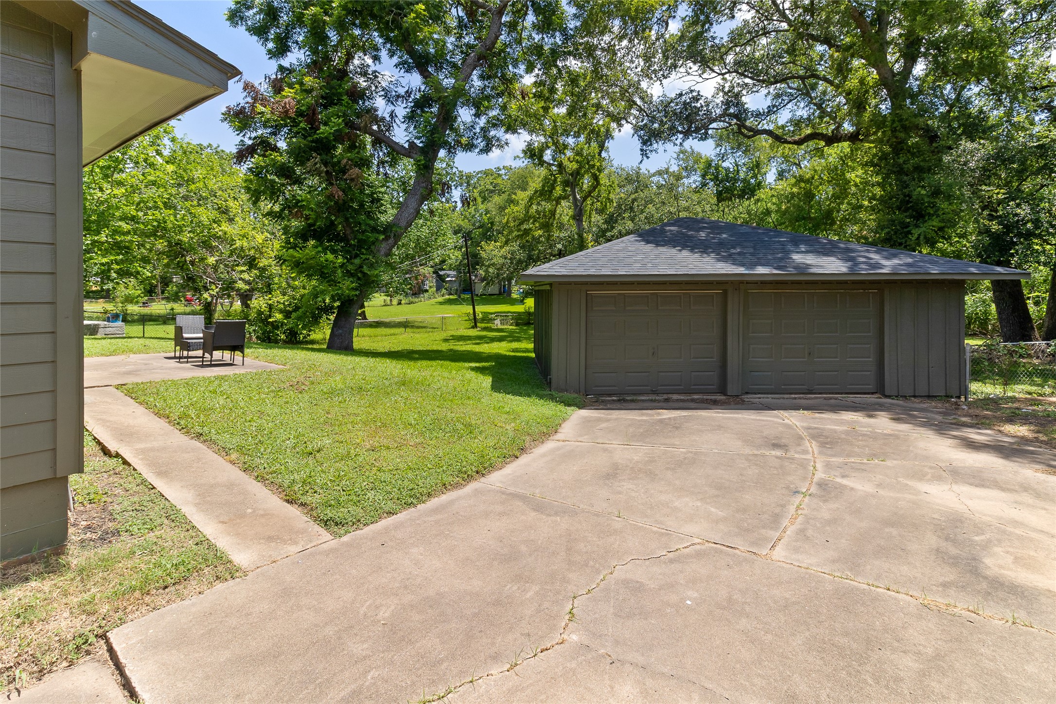117 Cannon Street Clute, TX 77531 - Photo 22 of 24 Tucked behind the home, the detached garage adds useful storage and parking, with mature trees giving the area a shaded backdrop.