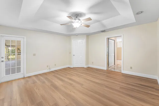 an empty room with wooden floor and windows