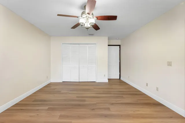 a view of an empty room with a chandelier fan