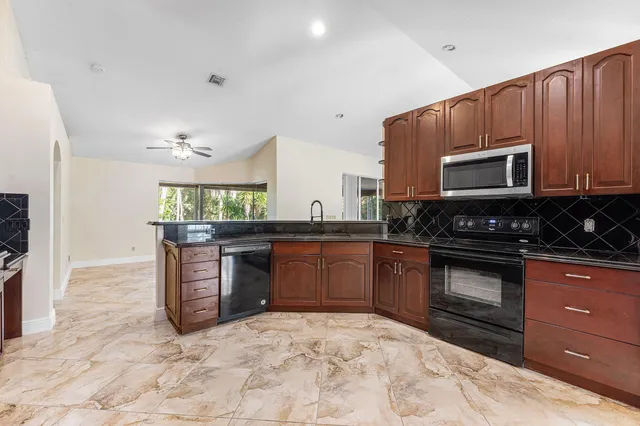 a kitchen with stainless steel appliances granite countertop a stove a sink and a microwave