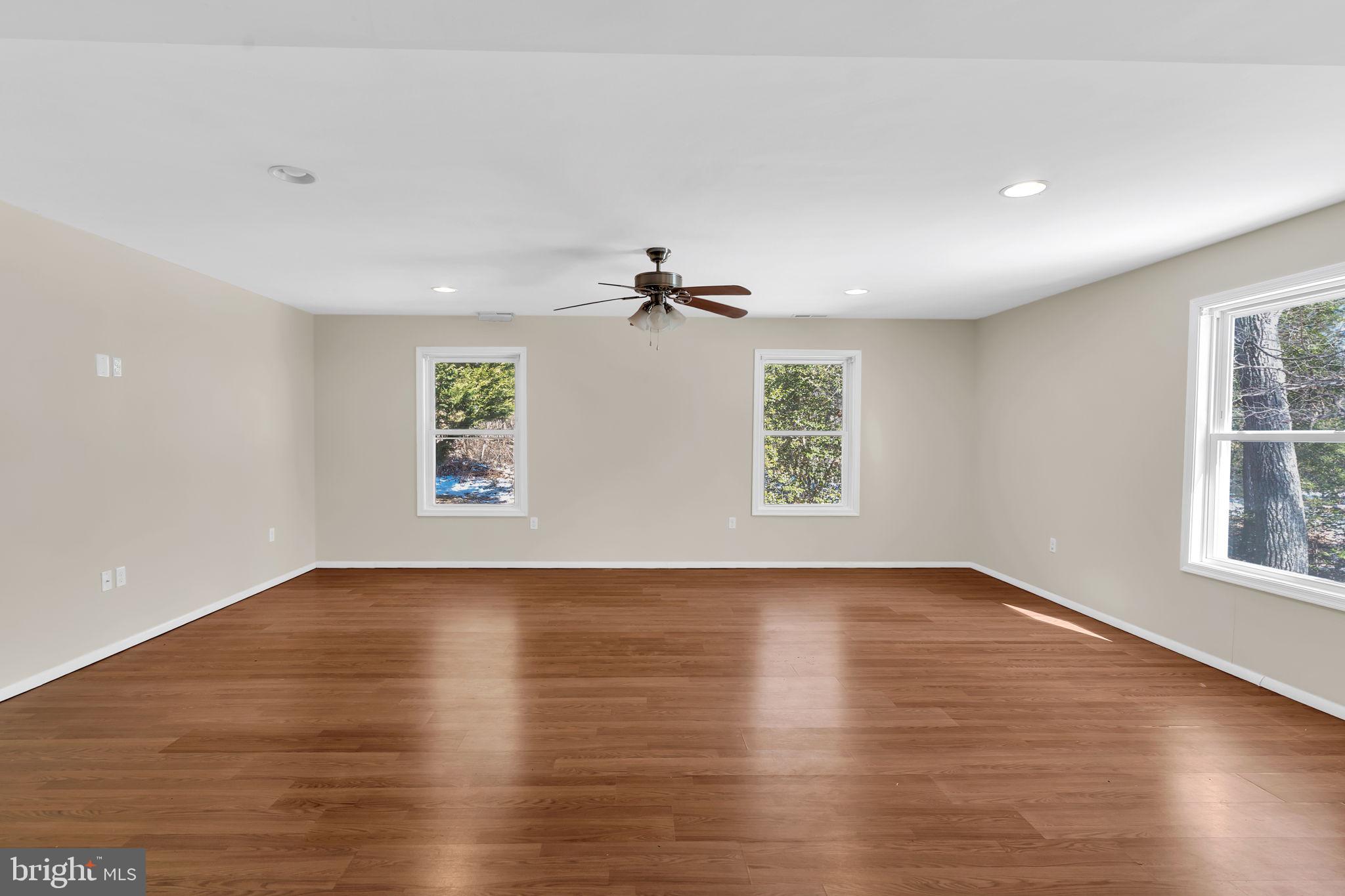 1150 Calvert Beach Road St. Leonard, MD 20685 - Photo 18 of 42 an empty room with wooden floor chandelier and windows