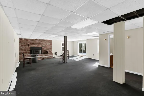 a view of a livingroom with fireplace and window